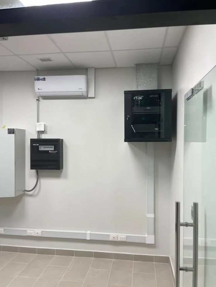 Sala técnica del Túnel ACHS con canalización a la vista, panel de detección de incendio y rack.